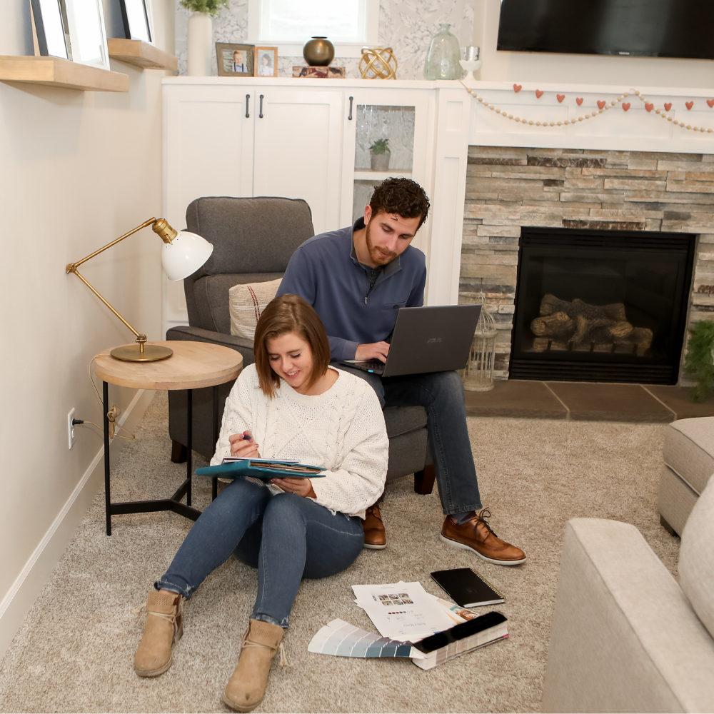 man and woman working together in living room