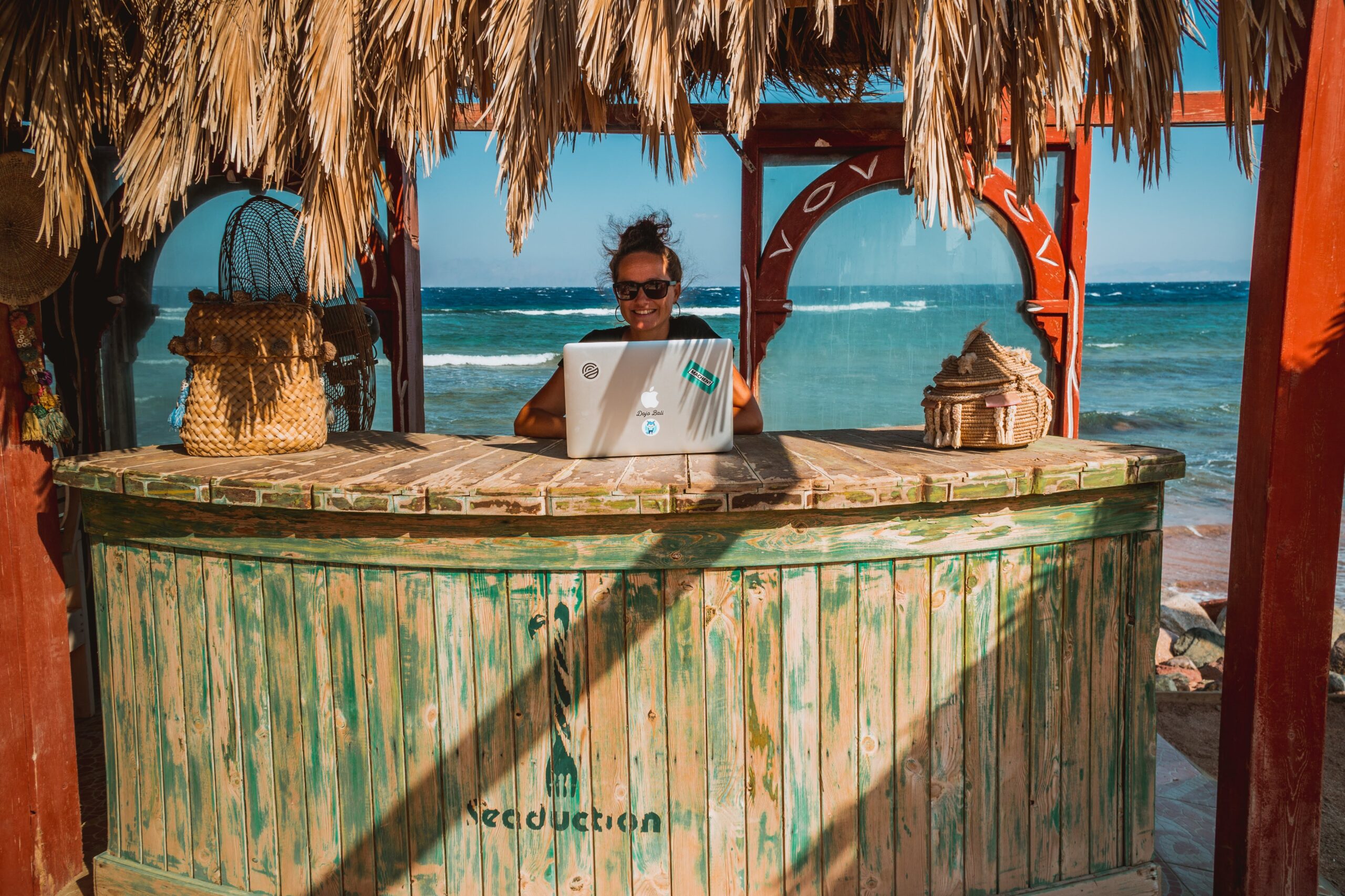 digital nomad woman working on the beach | Austin and Monica